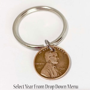 May include: A silver key chain with a 1931 US penny attached. The penny features a profile of Abraham Lincoln and the words "In God We Trust", "Liberty", and "1931". Select Year From Drop Down Menu.