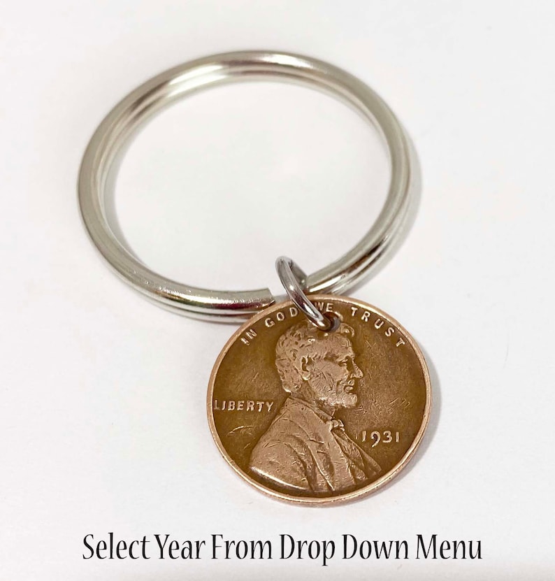 May include: A silver key chain with a 1931 US penny attached. The penny features a profile of Abraham Lincoln and the words "In God We Trust", "Liberty", and "1931". Select Year From Drop Down Menu.