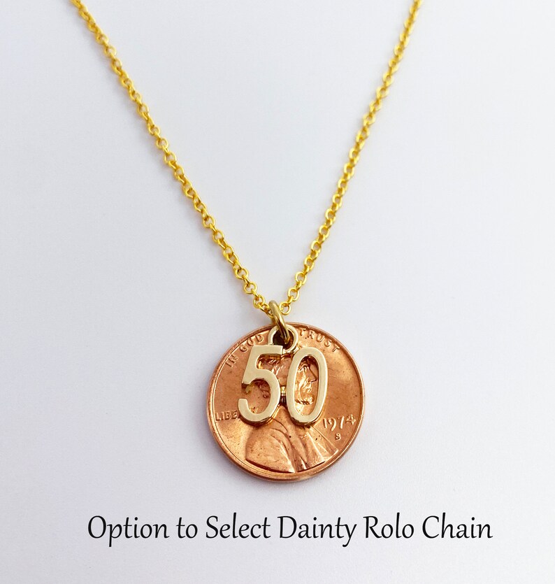 May include: Gold necklace with a copper penny pendant featuring the number 50. The penny is dated 1974. Option to select dainty rolo chain.