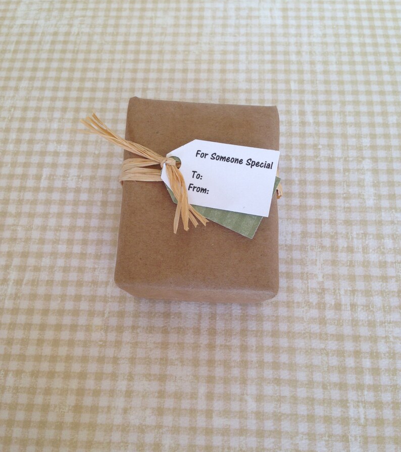 K&ouml;nnte beinhalten: Eine braune Geschenkbox aus Papier mit einem wei&szlig;en Etikett, auf dem "For Someone Special" steht und Platz f&uuml;r "To:" und "From:" ist. Die Box ist mit einem nat&uuml;rlichen Bastband gebunden.