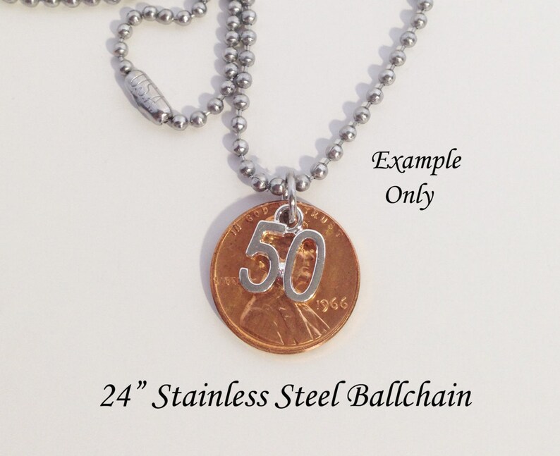 May include: A silver-colored number 50 charm pendant hangs from a stainless steel ball chain necklace. The pendant is attached to a copper penny. The text "Example Only" is visible. The necklace is 24 inches long.
