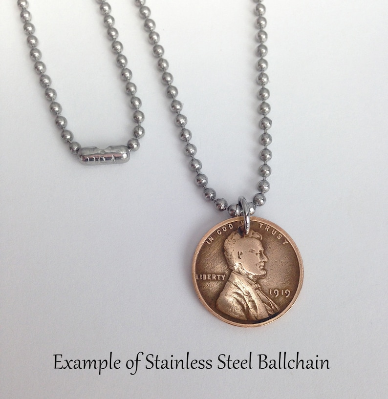 May include: A silver ball chain necklace with a 1919 penny pendant. The penny has the words "In God We Trust" and "Liberty" on it. The pendant is attached to the chain with a silver jump ring. Example of Stainless Steel Ballchain.