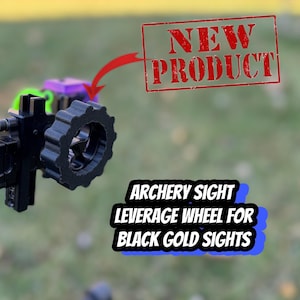 May include: Black archery sight leverage wheel for Black Gold sights. The wheel is made of black plastic and has a textured surface. It is attached to a black metal bracket.