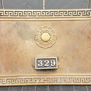 Pode incluir: Uma placa de madeira artesanal com o texto "Welcome to our home" em estilo manuscrito. A placa é pintada de branco com letras pretas e um acabamento envelhecido, adequada para uso interno ou externo.