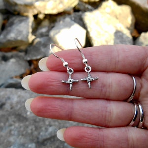 May include: A pair of silver earrings with a Celtic cross design. The earrings are small and delicate, and they would make a great gift for someone who loves Celtic culture.