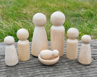 May include: A set of seven wooden peg dolls, including a baby doll in a cradle. The dolls are unpainted and have a natural wood finish.