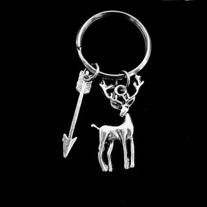 May include: Silver key chain with a deer charm and an arrow charm.