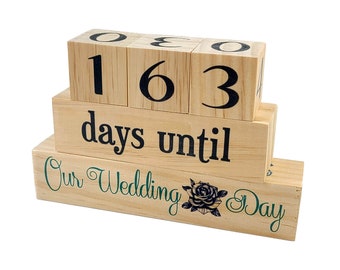 May include: Wooden countdown block set with the numbers 163 and the text "days until Our Wedding Day" with a green rose graphic.