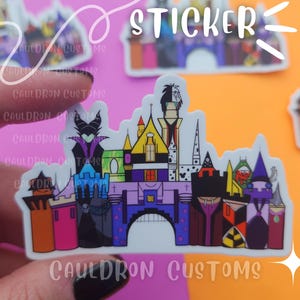 Puede incluir: Una pegatina blanca con una ilustraci&oacute;n colorida de un castillo con un esquema de color morado, verde y amarillo. El castillo est&aacute; rodeado de varios personajes de la colecci&oacute;n de villanos de Disney, incluyendo Mal&eacute;fica, Cruella de Vil y &Uacute;rsula. La pegatina dice "CAULDRON CUSTOMS" en la parte inferior.