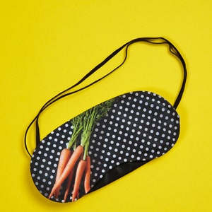 Peut inclure: Masque de sommeil noir à pois blancs avec une image imprimée de carottes sur fond jaune.