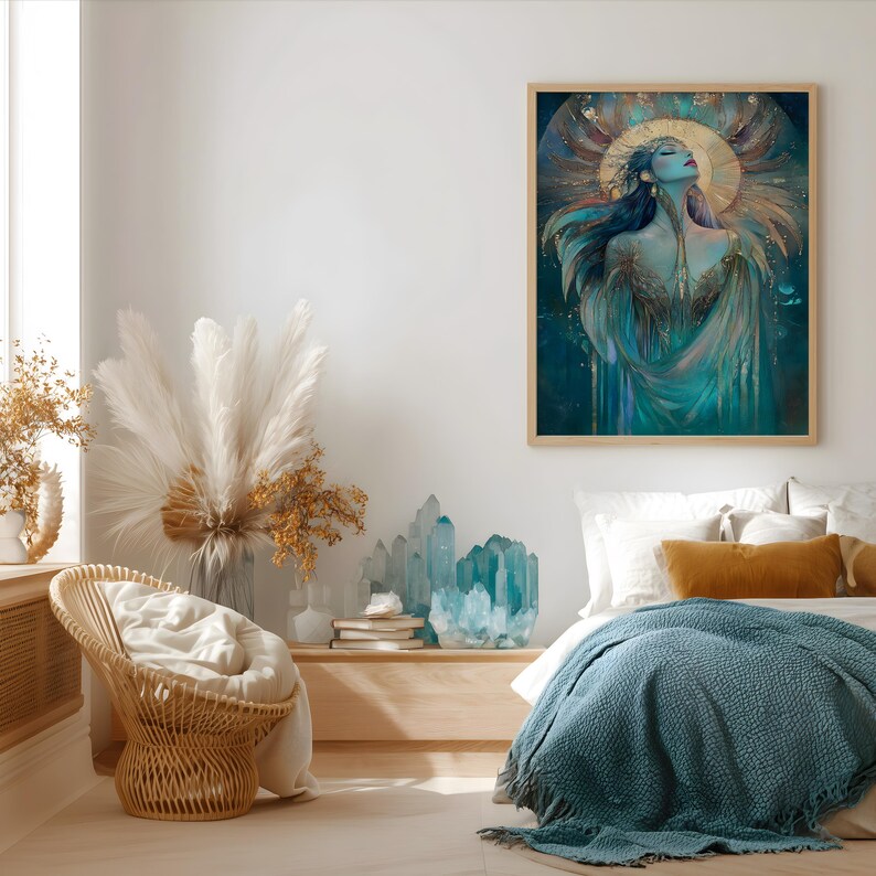 May include: A framed art print shows a woman with flowing hair and a golden halo, in teal, gold, and blue hues. The artwork hangs above a bed with a blue blanket and yellow cushions. A wicker chair and crystals are also visible.