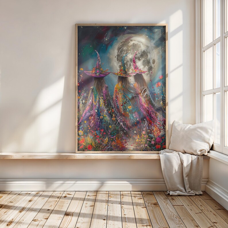 May include: Two witches in colorful robes and pointed hats stand in a field of flowers under a full moon. The moon is bright white and the sky is a deep blue with stars. The witches are facing away from the viewer and their robes are adorned with flowers and other details.