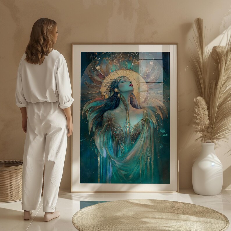 May include: A framed art print depicting a teal and gold illustration of a woman with closed eyes and outstretched arms. The artwork features a gold halo and flowing teal and gold garments. The print is in a light wood frame.