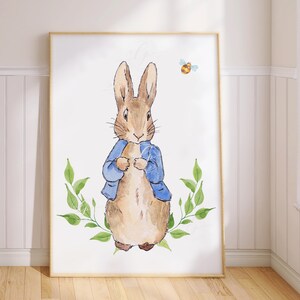 May include: A watercolour illustration of Peter Rabbit, a brown rabbit wearing a blue jacket, standing in front of green leaves. A small yellow bee is flying above the rabbit.