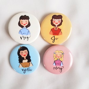 May include: Four round, colorful buttons with illustrations of women. Each button features a different woman's portrait and name: Meg, Jo, Beth, and Amy. The buttons are white, yellow, blue, and pink.