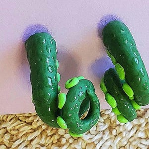 May include: A pair of green and lime green polymer clay earrings shaped like an octopus.