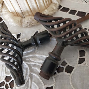 May include: Two antique door knobs with a black finish and a spiral design. The knobs are made of metal and have a decorative, ornate look.