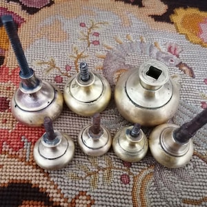 Puede incluir: Ocho pomos de armario de latón antiguo con una variedad de diseños. Los pomos tienen una base redonda y una parte superior roscada. Algunos pomos tienen una parte superior cuadrada, mientras que otros tienen una parte superior redonda.