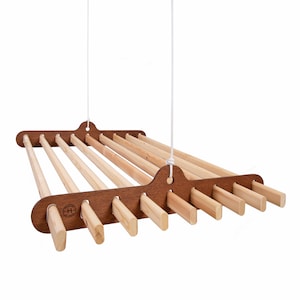 May include: A wooden ceiling mounted clothes drying rack with 10 wooden dowels. The rack is suspended by two white cords.