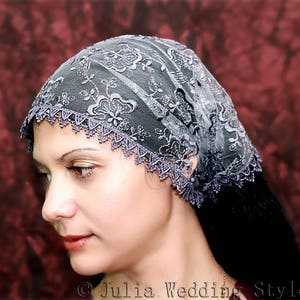 May include: A gray lace veil with a scalloped edge. The veil is worn by a person with long dark hair.