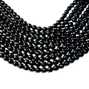 May include: A strand of black faceted gemstone beads. The beads are round and have a smooth, polished finish.