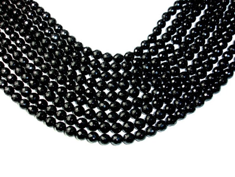 May include: A strand of black faceted gemstone beads. The beads are round and have a smooth, polished finish.