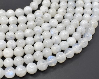 May include: A strand of white moonstone beads. The beads are round and smooth, with a slight iridescent sheen.