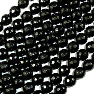 May include: A strand of black faceted gemstone beads. The beads are round and have a smooth, polished finish.