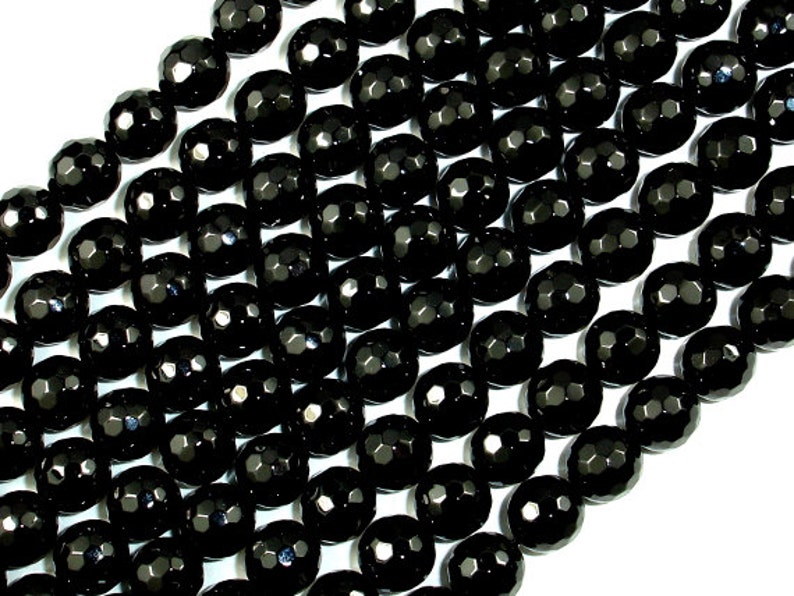 May include: A strand of black faceted gemstone beads. The beads are round and have a smooth, polished finish.