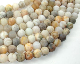 May include: A strand of agate beads in various shades of white, brown, and yellow. The beads are round and have a smooth, polished finish.
