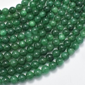 May include: A strand of round, green jade beads. The beads are smooth and polished, and they have a slightly translucent appearance.