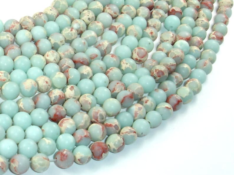 May include: A strand of light blue and brown round beads. The beads have a mottled pattern and are approximately 8mm in diameter.