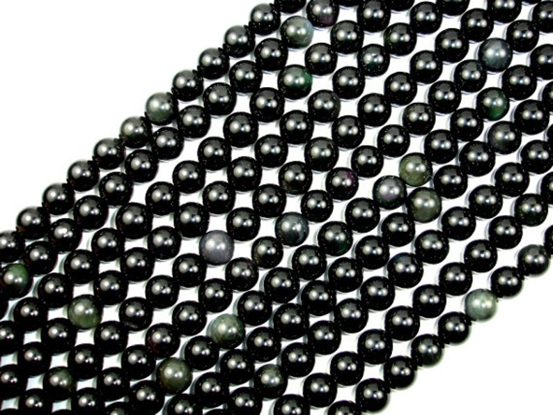 May include: A strand of black obsidian beads with a subtle green shimmer. The beads are round and smooth, and they are arranged in a staggered pattern.