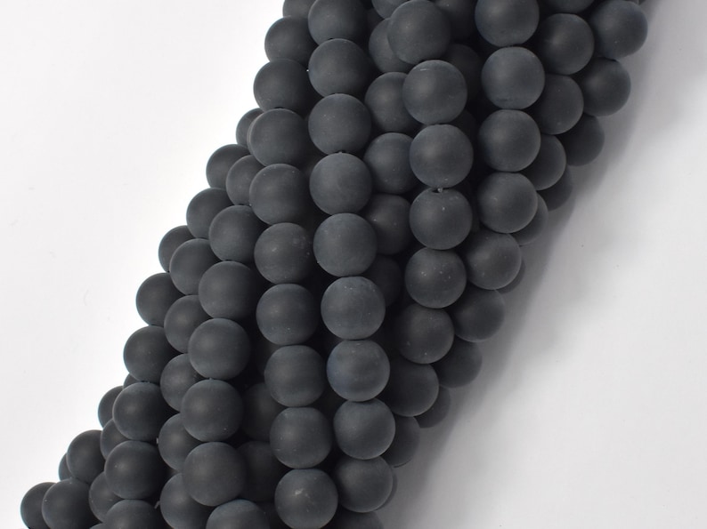May include: A strand of black matte round beads. The beads are smooth and have a slightly textured surface.