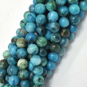May include: A strand of round, blue and green gemstone beads. The beads have a mottled, marbled appearance.