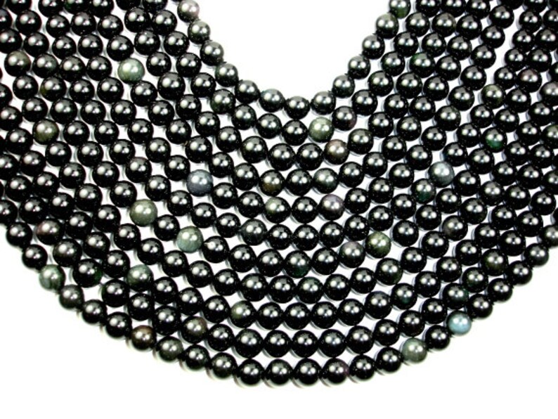 May include: A strand of black obsidian beads, each bead is round and smooth. The beads have a slight shimmer to them.