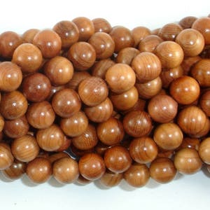 May include: A strand of round, wooden beads in a light brown colour. The beads are smooth and have a natural wood grain.