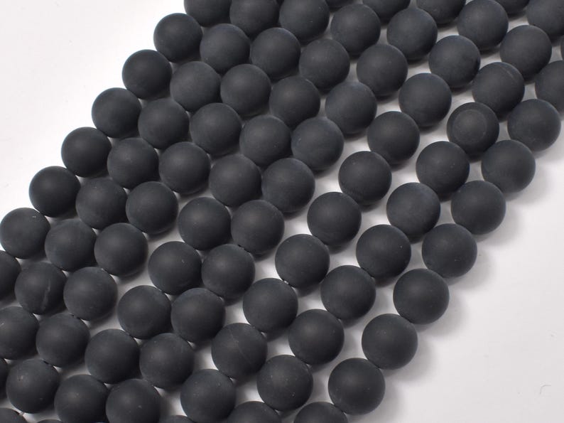 May include: A strand of black matte round beads. The beads are smooth and have a uniform size and shape.