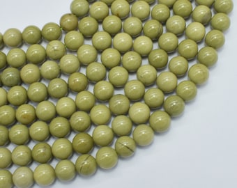 May include: A collection of olive-green, round beads. The beads are smooth and appear to be made of stone or a similar material. They are arranged closely together, suggesting they are strung for jewelry making or crafts.