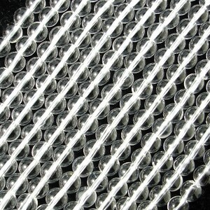 May include: A strand of clear glass beads, arranged in rows. The beads are round and smooth, with a slight shine.