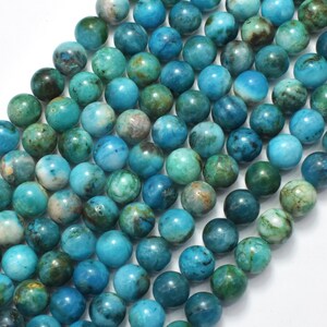 May include: A strand of round, blue and green gemstone beads. The beads have a mottled, marbled appearance.
