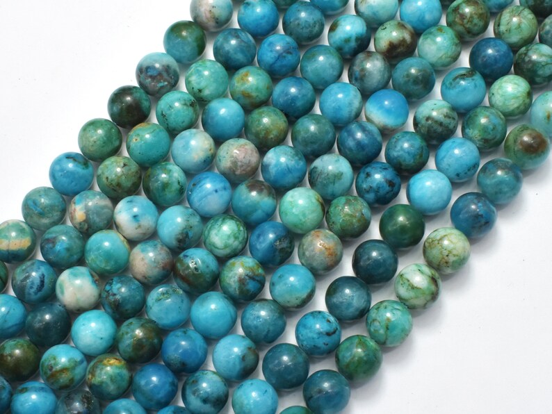 May include: A strand of round, blue and green gemstone beads. The beads have a mottled, marbled appearance.