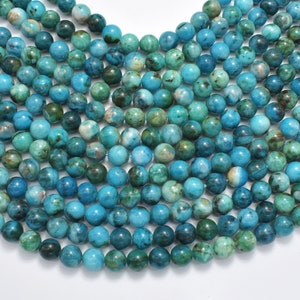 May include: A strand of turquoise blue gemstone beads with a mottled green and white pattern. The beads are round and smooth, and they are strung on a clear thread.
