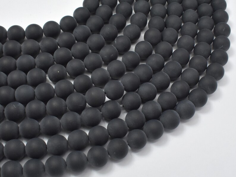 May include: A strand of matte black round beads. The beads are smooth and have a uniform size and shape.