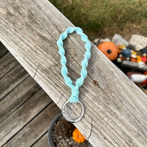 May include: A light blue crocheted key chain with a silver metal ring.