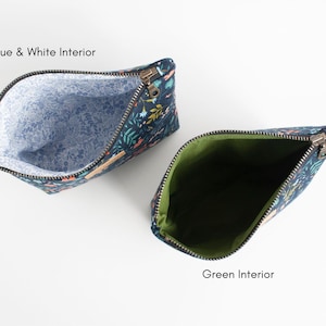 Peut inclure: Deux trousses zipp&eacute;es avec un ext&eacute;rieur bleu fonc&eacute; orn&eacute; d'un motif floral et de papillons color&eacute;s. L'une des trousses poss&egrave;de un int&eacute;rieur bleu clair et blanc &agrave; motifs floraux, tandis que l'autre pr&eacute;sente un int&eacute;rieur vert olive uni.