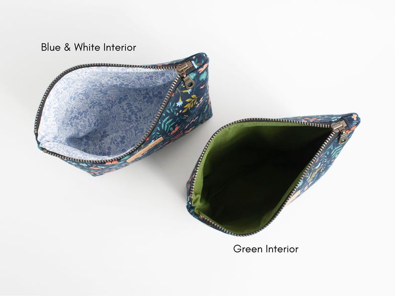 Peut inclure: Deux trousses zipp&eacute;es avec un ext&eacute;rieur bleu fonc&eacute; orn&eacute; d'un motif floral et de papillons color&eacute;s. L'une des trousses poss&egrave;de un int&eacute;rieur bleu clair et blanc &agrave; motifs floraux, tandis que l'autre pr&eacute;sente un int&eacute;rieur vert olive uni.