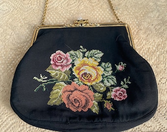 Pode incluir: Uma bolsa de noite vintage preta com uma alça de corrente dourada e um design bordado floral. O bordado apresenta rosas cor-de-rosa, amarelas e verdes.