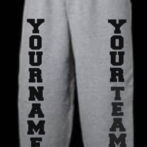 May include: Gray sweatpants with black vertical text on the legs that reads "YOUR NAME" on the left leg and "YOUR TEAM" on the right leg.