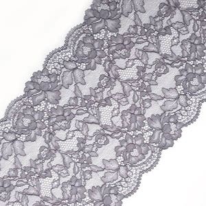 May include: Grey lace trim with a floral pattern. The lace is delicate and has a scalloped edge.
